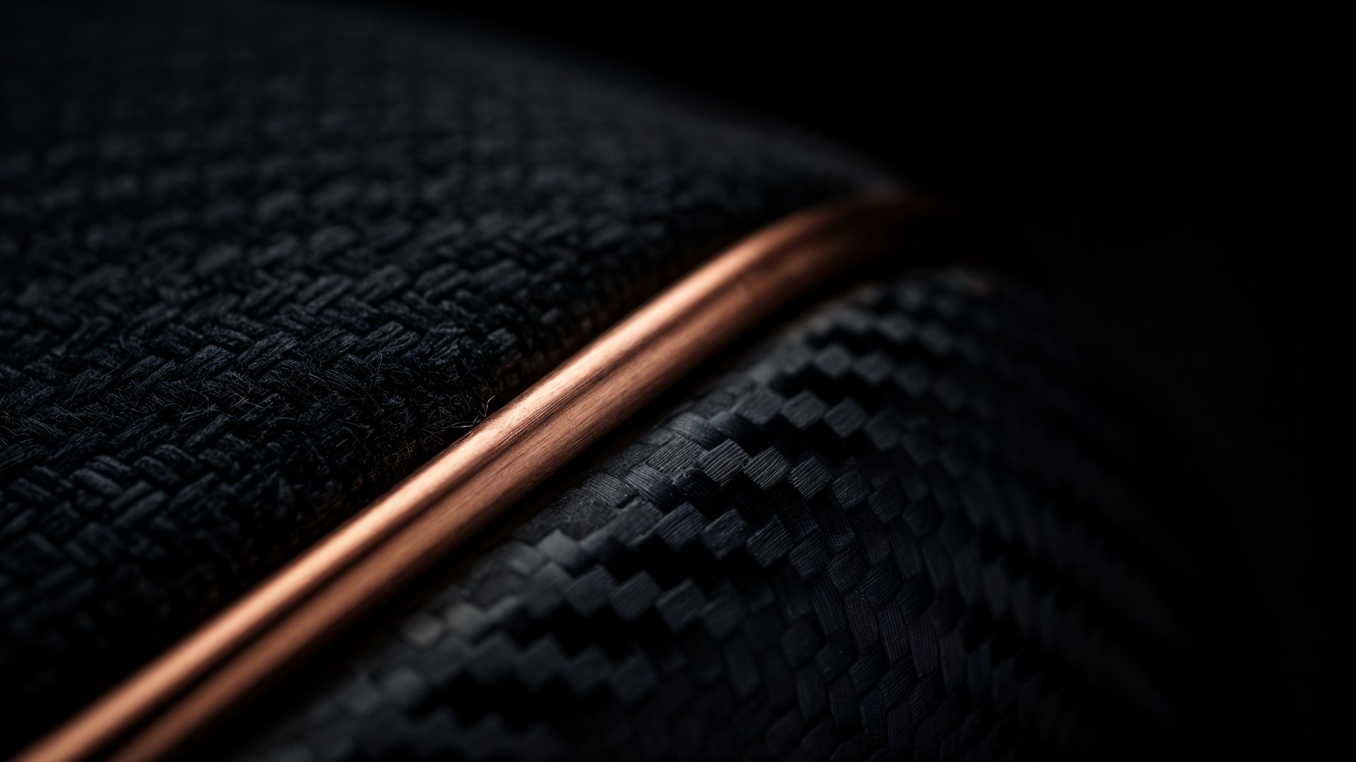 Close detail of dark textile and a brushed copper line